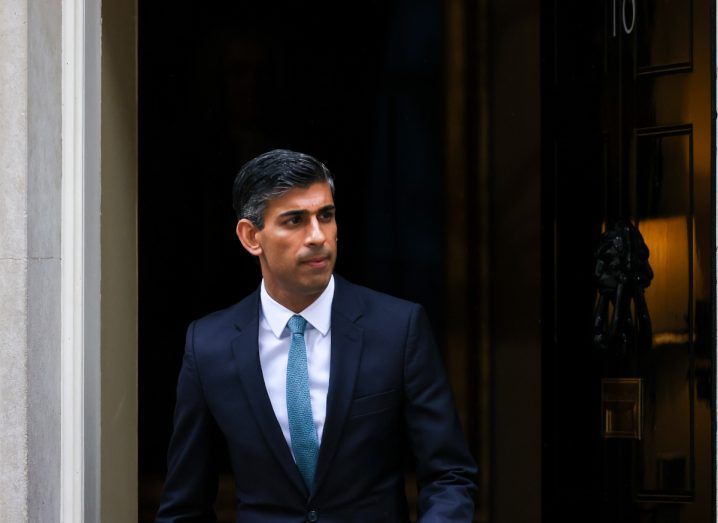 Photo of UK prime minister Rishi Sunak walking out through a door with the number 10 on it.