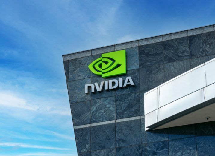 The Nvidia logo on the side of a building with a clear sky over it.