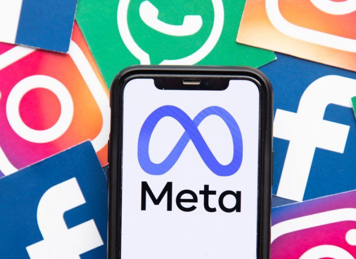 The Meta logo on a smartphone with multiple Meta app logos surrounding the phone, such as Facebook, Instagram and WhatsApp.
