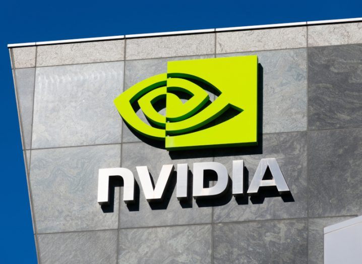 The Nvidia logo and sign on the side of a grey building, with a blue sky in the background.
