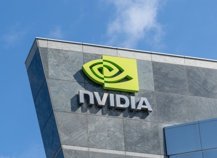 The Nvidia logo on the side of a grey building, with a blue sky in the background.