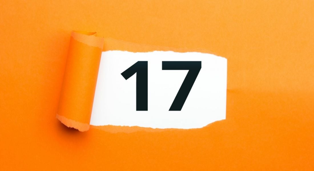 An image of an orange wallpaper being pulled off a wall, revealing the number 17 behind it.