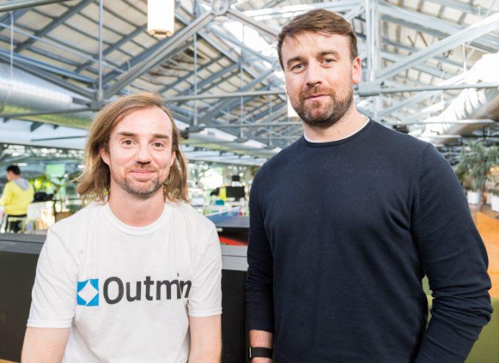 Ross Hunt, wearing a white Outmin T-shirt, pictured next to David Kelleher in the Dogpatch Labs base in Dublin.